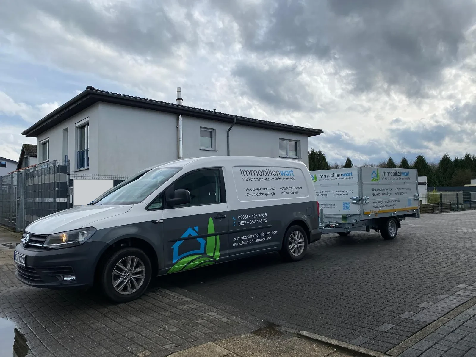 Firmenwagen von Immobilienwart mit Anhänger