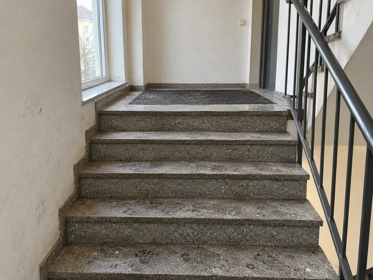 KI-Beispielbild: Treppenhaus mit Schmutz auf Stufen und Podest vor der Reinigung