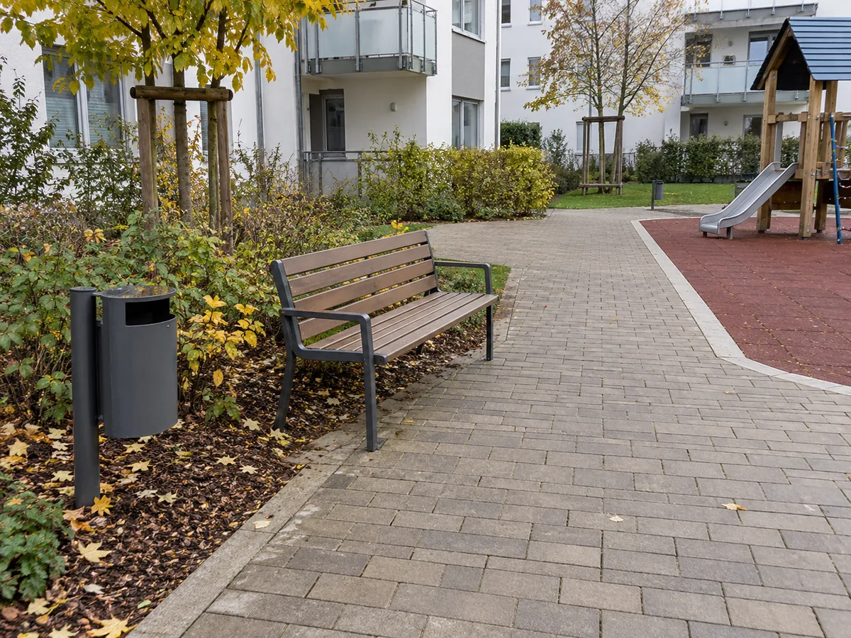 KI-generiertes Beispielbild: gereinigter Weg mit Sitzbank, Papierkorb und Spielbereich